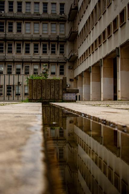 Brutalistische Betonfassade mit Spiegelung im Wasserbecken