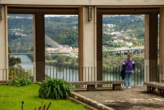 Blick durch Betonarkaden auf Fluss und Brücke in Porto